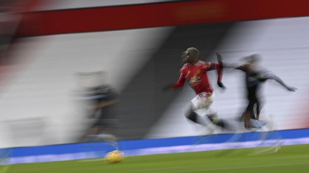 Manchester United's Paul Pogba, center gets past Aston Villa's Matt Targett, right, during the English Premier League soccer match between Manchester United and Aston Villa at Old Trafford in Manchester, England, Friday, Jan. 1, 2021. (Lawrence Griffiths/ Pool via AP)