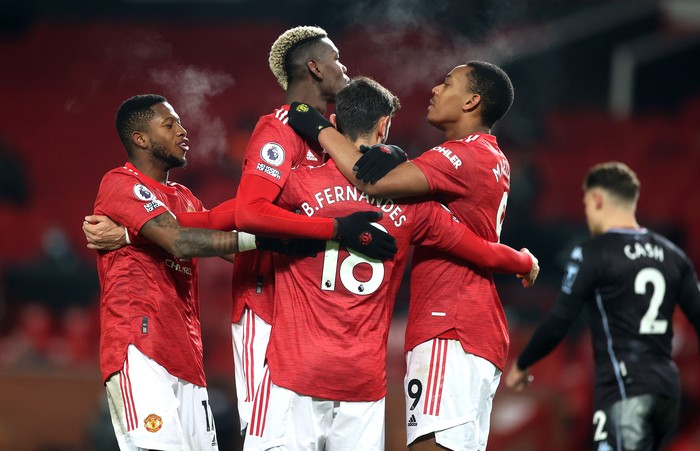 Manchester United MANCHESTER, ENGLAND - JANUARY 01: Bruno Fernandes of Manchester United celebrates with teammates (L-R) Fred, Paul Pogba and Anthony Martial after scoring their team's second goal during the Premier League match between Manchester United and Aston Villa at Old Trafford on January 01, 2021 in Manchester, England. The match will be played without fans, behind closed doors as a Covid-19 precaution. (Photo by Carl Recine - Pool/Getty Images)
