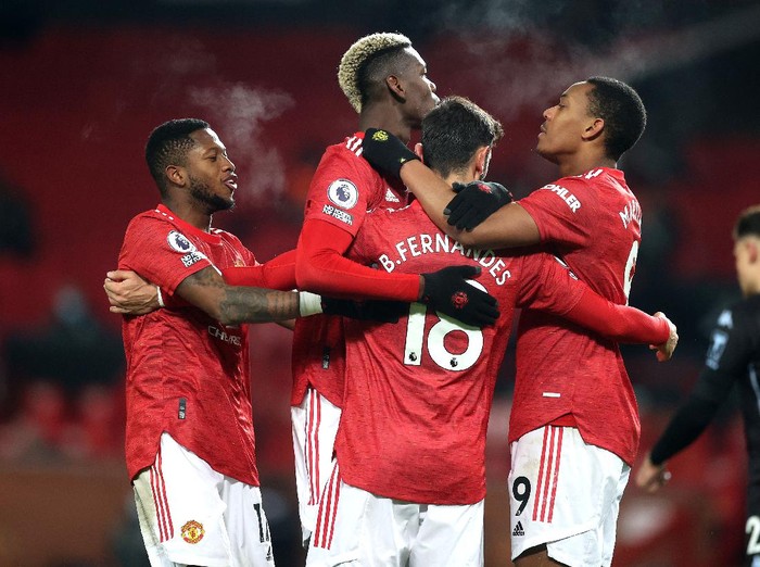 MANCHESTER, ENGLAND - JANUARY 01: Bruno Fernandes of Manchester United celebrates with teammates (L-R) Fred, Paul Pogba and Anthony Martial after scoring their team's second goal  during the Premier League match between Manchester United and Aston Villa at Old Trafford on January 01, 2021 in Manchester, England. The match will be played without fans, behind closed doors as a Covid-19 precaution. (Photo by Carl Recine - Pool/Getty Images)
