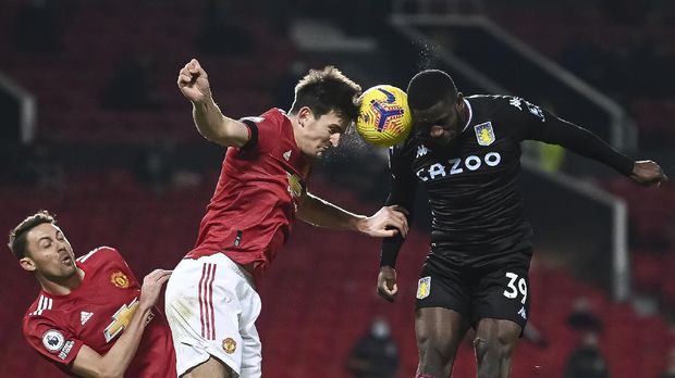 Manchester United's Harry Maguire, left and Aston Villa's Keinan Davis head the ball together during the English Premier League soccer match between Manchester United and Aston Villa at Old Trafford in Manchester, England, Friday, Jan. 1, 2021. (Lawrence Griffiths/ Pool via AP)