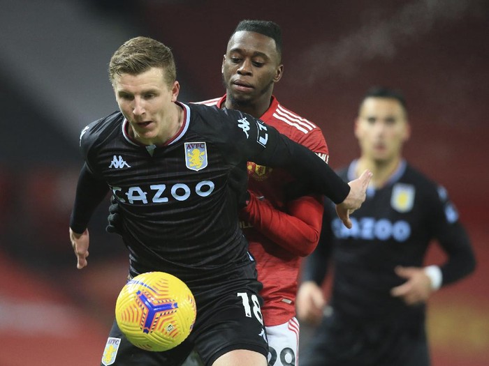 Aston Villas Matt Targett, left holds off the challenge of Manchester Uniteds Aaron Wan-Bissaka during the English Premier League soccer match between Manchester United and Aston Villa at Old Trafford in Manchester, England, Friday, Jan. 1, 2021. (Lawrence Griffiths/ Pool via AP)