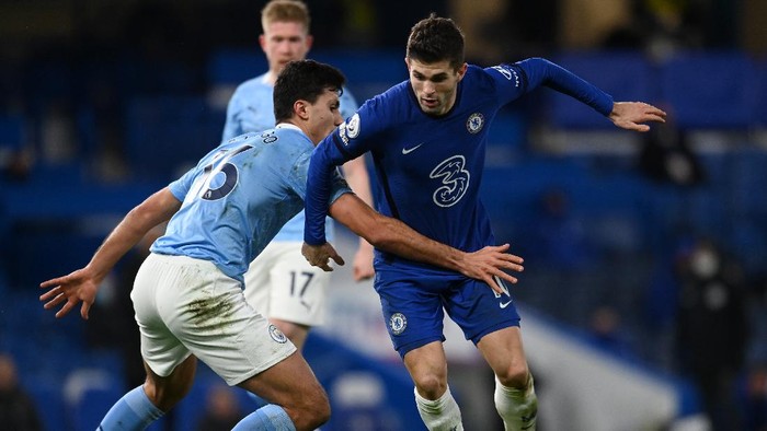 LONDON, ENGLAND - JANUARY 03: Christian Pulisic of Chelsea is tackled by Rodrigo of Manchester City during the Premier League match between Chelsea and Manchester City at Stamford Bridge on January 03, 2021 in London, England. The match will be played without fans, behind closed doors as a Covid-19 precaution. (Photo by Andy Rain - Pool/Getty Images)