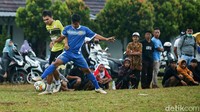 Rintik hujan tak membuat warga meninggalkan lapangan, mereka penasaran dengan permainan para pemain profesional tersebut.