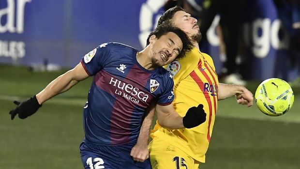 Huesca's Shinji Okazaki, left, vies for the ball with Barcelona's Clement Lenglet during the Spanish La Liga soccer match between Huesca and FC Barcelona at El Alcoraz stadium in Huesca, Spain, Sunday, Jan. 3, 2021. (AP Photo/Alvaro Barrientos)