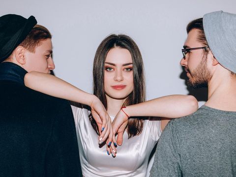 Polyamorous relationship. Modern partnership love. Confident woman dominating over two men.