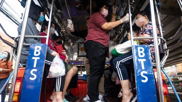 BANGKOK, THAILAND - JANUARY 03: Government officials from Bangkok Metropolitan Administration take body temperature of passengers on a pick-up truck taxi at a Covid-19 checkpoint on January 03, 2021 in Bangkok, Thailand. Bangkok will go into partial lockdown from Saturday night, and travel between Thai provinces will be curtailed from next week, as the country steps up efforts to control a quickly growing second wave of Covid-19 infections. (Photo by Sirachai Arunrugstichai/Getty Images)