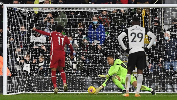 LONDON, ENGLAND - DECEMBER 13: Mohamed Salah of Liverpool  scores their teams first goal from the penalty spot past Alphonse Areola of Fulham during the Premier League match between Fulham and Liverpool at Craven Cottage on December 13, 2020 in London, England. A limited number of spectators (2000) are welcomed back to stadiums to watch elite football across England. This was following easing of restrictions on spectators in tiers one and two areas only. (Photo by Neil Hall - Pool/Getty Images)