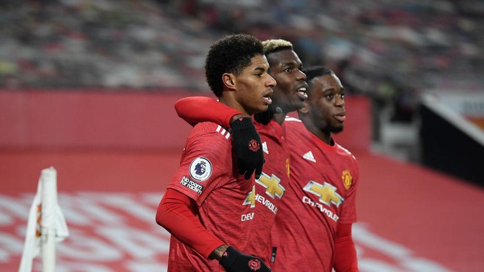 MANCHESTER, ENGLAND - DECEMBER 29: Marcus Rashford of Manchester United celebrates with teammates Paul Pogba and Aaron Wan-Bissaka after scoring his teams first goal during the Premier League match between Manchester United and Wolverhampton Wanderers at Old Trafford on December 29, 2020 in Manchester, England. The match will be played without fans, behind closed doors as a Covid-19 precaution. (Photo by Michael Regan/Getty Images)