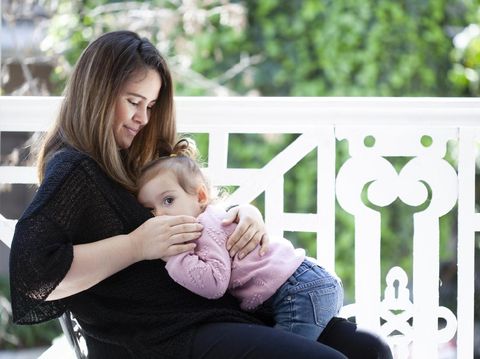 happy family photo of mother and daughter breastfeeding her baby