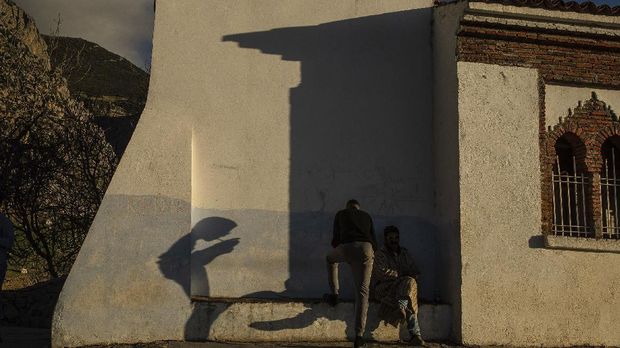 Nuansa Biru Kota Turis di Maroko A man lights a joint of cannabis atop a hill that tourists usually climb to observe the sunset, in Chefhchaouen, northern Morocco, Saturday, Dec. 26, 2020. The picturesque town, its facades painted in distinctive hues of blue, shut its small population off from the world, and kept the virus out for months. Now, as the country cautiously reopens and tries to resuscitate its struggling economy, Chefchaouen stands subdued, deserted by the tourists that have long been its lifeblood.(AP Photo/Mosa'ab Elshamy)