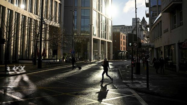 A pedestrian crosses an almost empty street in Manchester, north west England on January 5, 2021, as Britain enters a national lockdown to combat the spread of COVID-19. - England's six-week lockdown, which began at midnight, emulates the first national coronavirus curbs in place from March to June -- but goes further than another instituted in November when schools remained open. Authorities in Wales, Scotland and Northern Ireland have all taken similar measures, putting the UK as a whole in lockdown. (Photo by Oli SCARFF / AFP)