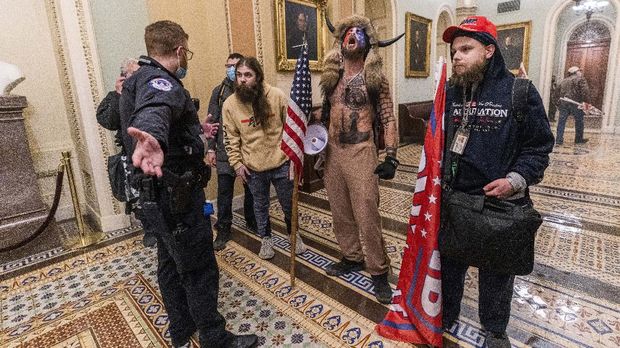 Supporters of President Donald Trump are confronted by Capitol Police officers outside the Senate Chamber inside the Capitol, Wednesday, Jan. 6, 2021 in Washington. (AP Photo/Manuel Balce Ceneta)