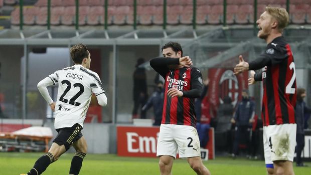 Juventus' Federico Chiesa, left, celebrates after scoring his side's second goal during the Serie A soccer match between AC Milan and Juventus at the San Siro stadium, in Milan, Italy, Wednesday, Jan. 6, 2021. (AP Photo/Antonio Calanni)