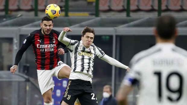 AC Milan's Theo Hernandez, left, jumps for the ball with Juventus' Federico Chiesa during the Serie A soccer match between AC Milan and Juventus at the San Siro stadium, in Milan, Italy, Wednesday, Jan. 6, 2021. (AP Photo/Antonio Calanni)
