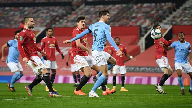 MANCHESTER, ENGLAND - JANUARY 06: John Stones of Manchester City scores their team's first goal during the Carabao Cup Semi Final match between Manchester United and Manchester City at Old Trafford on January 06, 2021 in Manchester, England. The match will be played without fans, behind closed doors as a Covid-19 precaution. (Photo by Shaun Botterill/Getty Images)