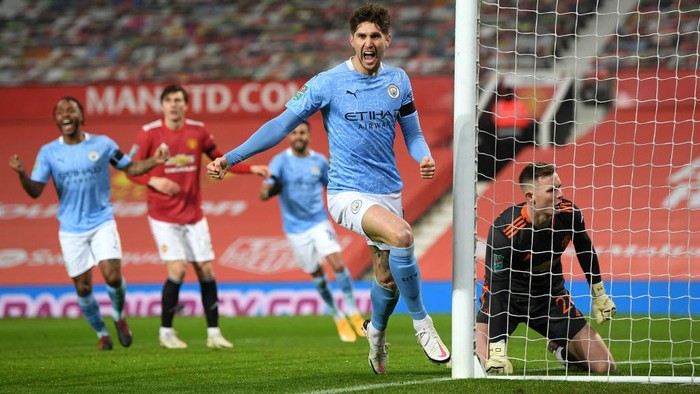 MANCHESTER, ENGLAND - JANUARY 06: John Stones of Manchester City celebrates after scoring their teams first goal during the Carabao Cup Semi Final match between Manchester United and Manchester City at Old Trafford on January 06, 2021 in Manchester, England. The match will be played without fans, behind closed doors as a Covid-19 precaution. (Photo by Shaun Botterill/Getty Images)