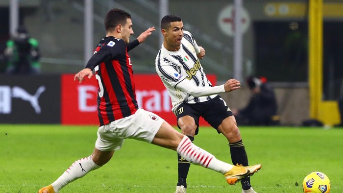 MILAN, ITALY - JANUARY 06: Cristiano Ronaldo of Juventus F.C. shoots past Diogo Dalot of A.C. Milan during the Serie A match between AC Milan and Juventus at Stadio Giuseppe Meazza on January 06, 2021 in Milan, Italy. Sporting stadiums around Italy remain under strict restrictions due to the Coronavirus Pandemic as Government social distancing laws prohibit fans inside venues resulting in games being played behind closed doors. (Photo by Marco Luzzani/Getty Images)