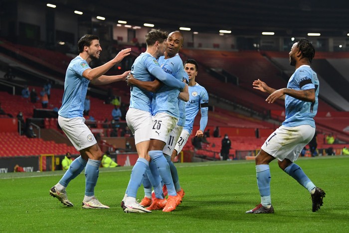 MANCHESTER, ENGLAND - JANUARY 06: John Stones of Manchester City celebrates with (l-r) Ruben Dias, Fernandinho, Ferran Torres and Raheem Sterling of Manchester City after scoring his sides 1st goal during the Carabao Cup Semi Final match between Manchester United and Manchester City at Old Trafford on January 06, 2021 in Manchester, England. The match will be played without fans, behind closed doors as a Covid-19 precaution. (Photo by Shaun Botterill/Getty Images)