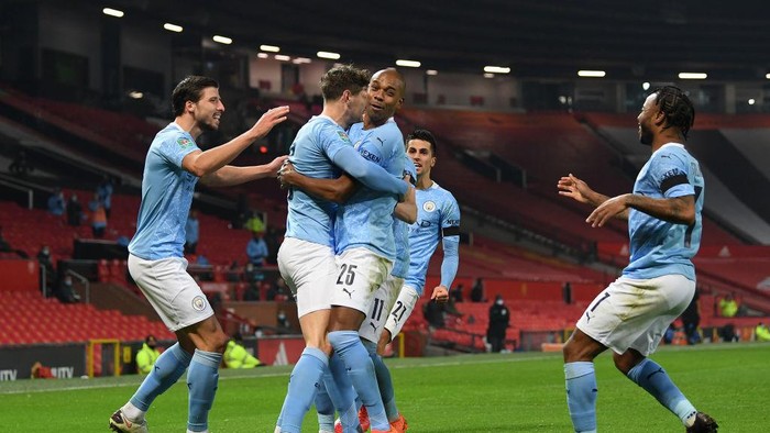 MANCHESTER, ENGLAND - JANUARY 06: John Stones of Manchester City celebrates with (l-r) Ruben Dias, Fernandinho, Ferran Torres and Raheem Sterling of Manchester City after scoring his sides 1st goal during the Carabao Cup Semi Final match between Manchester United and Manchester City at Old Trafford on January 06, 2021 in Manchester, England. The match will be played without fans, behind closed doors as a Covid-19 precaution. (Photo by Shaun Botterill/Getty Images)