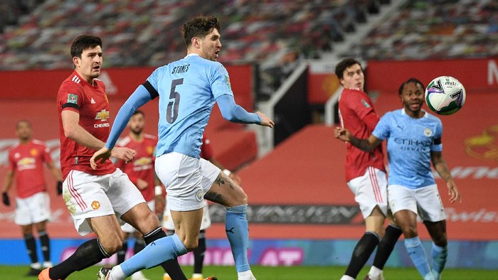 MANCHESTER, ENGLAND - JANUARY 06: John Stones of Manchester City scores their teams first goal during the Carabao Cup Semi Final match between Manchester United and Manchester City at Old Trafford on January 06, 2021 in Manchester, England. The match will be played without fans, behind closed doors as a Covid-19 precaution. (Photo by Shaun Botterill/Getty Images)