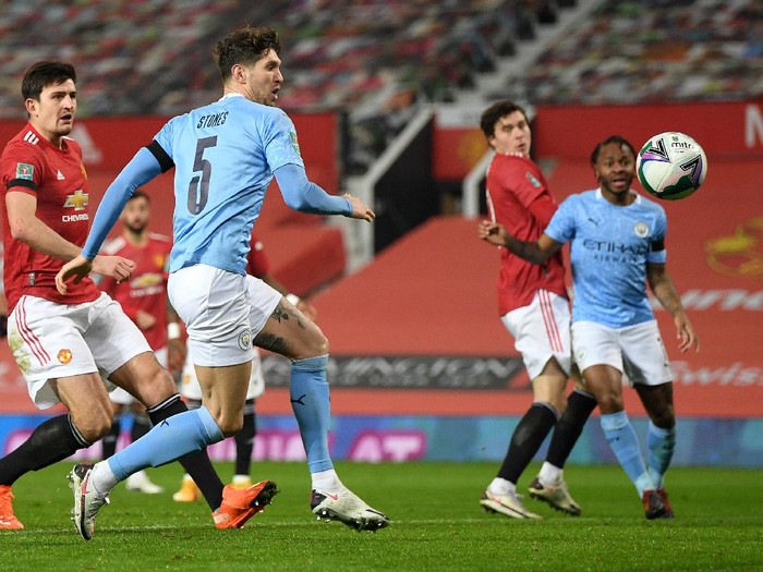 MANCHESTER, ENGLAND - JANUARY 06: John Stones of Manchester City scores their teams first goal during the Carabao Cup Semi Final match between Manchester United and Manchester City at Old Trafford on January 06, 2021 in Manchester, England. The match will be played without fans, behind closed doors as a Covid-19 precaution. (Photo by Shaun Botterill/Getty Images)