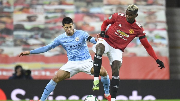 MANCHESTER, ENGLAND - JANUARY 06: Joao Cancelo of Manchester City battles for possession with Paul Pogba of Manchester United during the Carabao Cup Semi Final match between Manchester United and Manchester City at Old Trafford on January 06, 2021 in Manchester, England. The match will be played without fans, behind closed doors as a Covid-19 precaution. (Photo by Peter Powell - Pool/Getty Images)