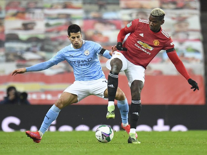 MANCHESTER, ENGLAND - JANUARY 06: Joao Cancelo of Manchester City battles for possession with Paul Pogba of Manchester United during the Carabao Cup Semi Final match between Manchester United and Manchester City at Old Trafford on January 06, 2021 in Manchester, England. The match will be played without fans, behind closed doors as a Covid-19 precaution. (Photo by Peter Powell - Pool/Getty Images)