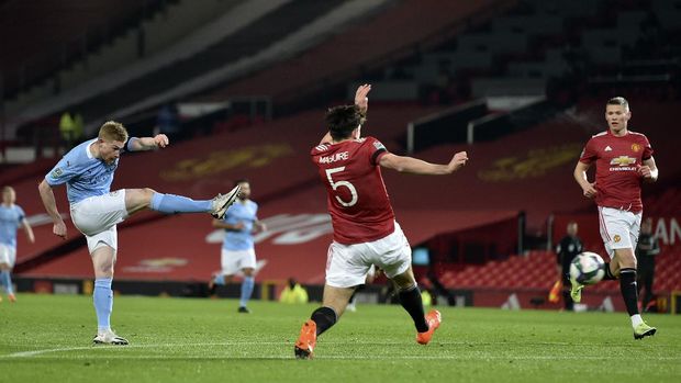 Manchester City's Kevin De Bruyne, left, shots the ball during the English League Cup semifinal soccer match between Manchester United and Manchester City at Old Trafford in Manchester, England, Wednesday, Jan. 6, 2021. (Peter Powell/Pool via AP)