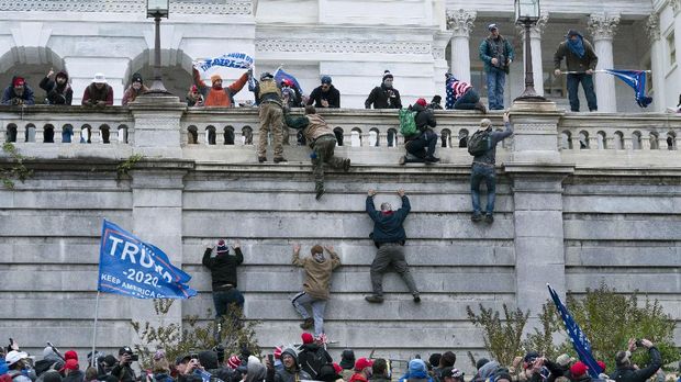 Supporters of President Donald Trump climb the west wall of the the U.S. Capitol on Wednesday, Jan. 6, 2021, in Washington. (AP Photo/Jose Luis Magana)