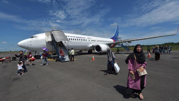 Passengers of a Sriwijaya Air flight disembark from the airplane at the Fatmawati airport in Bengkulu on June 1, 2018. - Sriwijaya Air is an Indonesian carrier and offers flights to various Indonesian destinations and a few international destinations. (Photo by Adek BERRY / AFP)