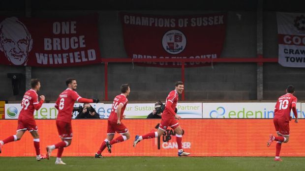 CRAWLEY, ENGLAND - JANUARY 10: Jordan Tunnicliffe of Crawley Town celebrates with team mates after scoring their side's third goal during the FA Cup Third Round match between Crawley Town and Leeds United at The Peoples Pension Stadium on January 10, 2021 in Crawley, England. Sporting stadiums around England remain under strict restrictions due to the Coronavirus Pandemic as Government social distancing laws prohibit fans inside venues resulting in games being played behind closed doors. (Photo by Mike Hewitt/Getty Images)