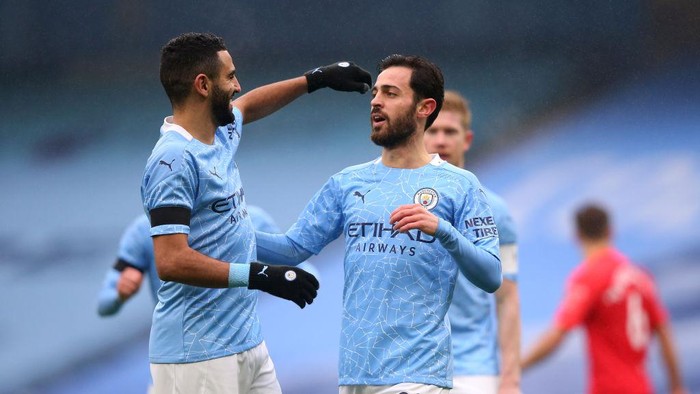 MANCHESTER, ENGLAND - JANUARY 10: Bernardo Silva of Manchester City celebrates with team mate Riyad Mahrez after scoring their sides first goal during the FA Cup Third Round match between Manchester City and Birmingham City at Etihad Stadium on January 10, 2021 in Manchester, England. Sporting stadiums around England remain under strict restrictions due to the Coronavirus Pandemic as Government social distancing laws prohibit fans inside venues resulting in games being played behind closed doors. (Photo by Alex Livesey/Getty Images)