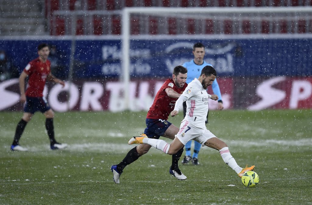 PAMPLONA, SPAIN - JANUARY 09: Eden Hazard of Real Madrid is challenged by Jon Moncayola of Osasuna during the La Liga Santander match between C.A. Osasuna and Real Madrid at Estadio El Sadar on January 09, 2021 in Pamplona, Spain. Sporting stadiums around Spain remain under strict restrictions due to the Coronavirus Pandemic as Government social distancing laws prohibit fans inside venues resulting in games being played behind closed doors. (Photo by Juan Manuel Serrano Arce/Getty Images)