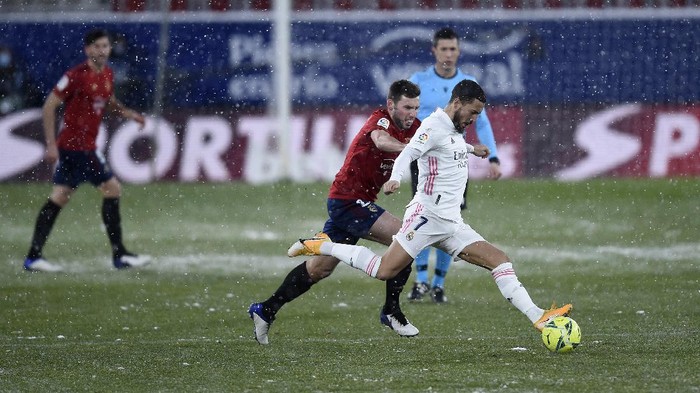 PAMPLONA, SPAIN - JANUARY 09: Eden Hazard of Real Madrid is challenged by Jon Moncayola of Osasuna during the La Liga Santander match between C.A. Osasuna and Real Madrid at Estadio El Sadar on January 09, 2021 in Pamplona, Spain. Sporting stadiums around Spain remain under strict restrictions due to the Coronavirus Pandemic as Government social distancing laws prohibit fans inside venues resulting in games being played behind closed doors. (Photo by Juan Manuel Serrano Arce/Getty Images)