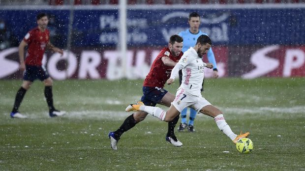 PAMPLONA, SPAIN - JANUARY 09: Eden Hazard of Real Madrid is challenged by Jon Moncayola of Osasuna during the La Liga Santander match between C.A. Osasuna and Real Madrid at Estadio El Sadar on January 09, 2021 in Pamplona, Spain. Sporting stadiums around Spain remain under strict restrictions due to the Coronavirus Pandemic as Government social distancing laws prohibit fans inside venues resulting in games being played behind closed doors. (Photo by Juan Manuel Serrano Arce/Getty Images)
