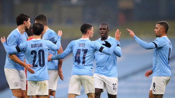 MANCHESTER, ENGLAND - JANUARY 10: Phil Foden of Manchester City celebrates with team mates Gabriel Jesus and Benjamin Mendy after scoring their sides third goal during the FA Cup Third Round match between Manchester City and Birmingham City at Etihad Stadium on January 10, 2021 in Manchester, England. Sporting stadiums around England remain under strict restrictions due to the Coronavirus Pandemic as Government social distancing laws prohibit fans inside venues resulting in games being played behind closed doors. (Photo by Alex Livesey/Getty Images)