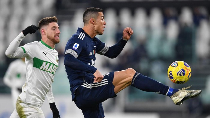 TURIN, ITALY - JANUARY 10: Cristiano Ronaldo of Juventus F.C. controls the ball under pressure from Georgios Kyriakopoulos of Sassuolo during the Serie A match between Juventus and US Sassuolo at Allianz Stadium on January 10, 2021 in Turin, Italy. Sporting stadiums around Italy remain under strict restrictions due to the Coronavirus Pandemic as Government social distancing laws prohibit fans inside venues resulting in games being played behind closed doors. (Photo by Valerio Pennicino/Getty Images )
