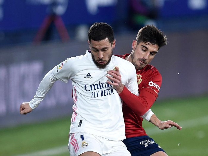 PAMPLONA, SPAIN - JANUARY 09: Eden Hazard of Real Madrid holds off Nacho Vidal of Osasuna during the La Liga Santander match between C.A. Osasuna and Real Madrid at Estadio El Sadar on January 09, 2021 in Pamplona, Spain. Sporting stadiums around Spain remain under strict restrictions due to the Coronavirus Pandemic as Government social distancing laws prohibit fans inside venues resulting in games being played behind closed doors. (Photo by Juan Manuel Serrano Arce/Getty Images)