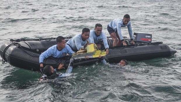Sejumlah prajurit Satuan Komando Pasukan Katak (Satkopaska) Armada 1 berusaha mengangkat puing pesawat Sriwijaya Air SJ 182 dari dasar perairan Kepulauan Seribu, Jakarta, Senin (11/1/2021). Pesawat Sriwijaya Air SJ 182 pada hari Sabtu (9/1/2021) hilang kontak dan diperkirakan jatuh di antara Pulau Laki dan Pulau Lancang. ANTARA FOTO/M Risyal Hidayat/hp.