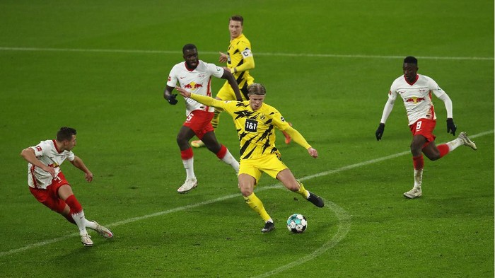 LEIPZIG, GERMANY - JANUARY 09: Erling Haland of Borussia Dortmund shoots at goal under pressure from Dayot Upamecano and Amadou Haidara during the Bundesliga match between RB Leipzig and Borussia Dortmund at Red Bull Arena on January 09, 2021 in Leipzig, Germany. Sporting stadiums around Germany remain under strict restrictions due to the Coronavirus Pandemic as Government social distancing laws prohibit fans inside venues resulting in games being played behind closed doors. (Photo by Maja Hitij/Getty Images)