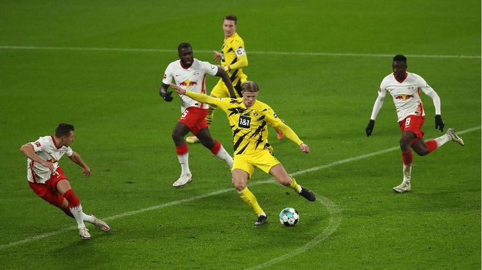 Erling Haaland Borussia Dortmund LEIPZIG, GERMANY - JANUARY 09: Erling Haland of Borussia Dortmund shoots at goal under pressure from Dayot Upamecano and Amadou Haidara during the Bundesliga match between RB Leipzig and Borussia Dortmund at Red Bull Arena on January 09, 2021 in Leipzig, Germany. Sporting stadiums around Germany remain under strict restrictions due to the Coronavirus Pandemic as Government social distancing laws prohibit fans inside venues resulting in games being played behind closed doors. (Photo by Maja Hitij/Getty Images)