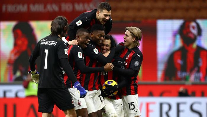 1296050504 MILAN, ITALY - JANUARY 12: Hakan Calhanoglu of A.C. Milan celebrates with team mates after scoring the winning penalty during a penalty shoot out during the Coppa Italia match between AC Milan and Torino FC at Stadio Giuseppe Meazza on January 12, 2021 in Milan, Italy. Sporting stadiums around Italy remain under strict restrictions due to the Coronavirus Pandemic as Government social distancing laws prohibit fans inside venues resulting in games being played behind closed doors. (Photo by Marco Luzzani/Getty Images)