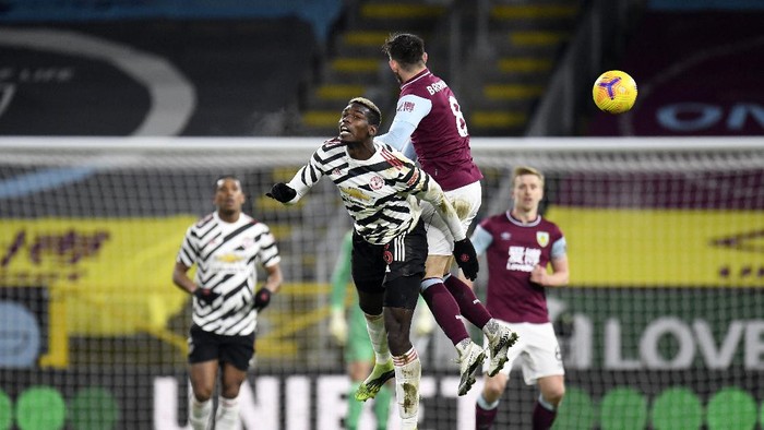 BURNLEY, ENGLAND - JANUARY 12: Paul Pogba of Manchester United and Josh Brownhill of Burnley contest a header during the Premier League match between Burnley and Manchester United at Turf Moor on January 12, 2021 in Burnley, England. Sporting stadiums around England remain under strict restrictions due to the Coronavirus Pandemic as Government social distancing laws prohibit fans inside venues resulting in games being played behind closed doors. (Photo by Peter Powell - Pool/Getty Images)