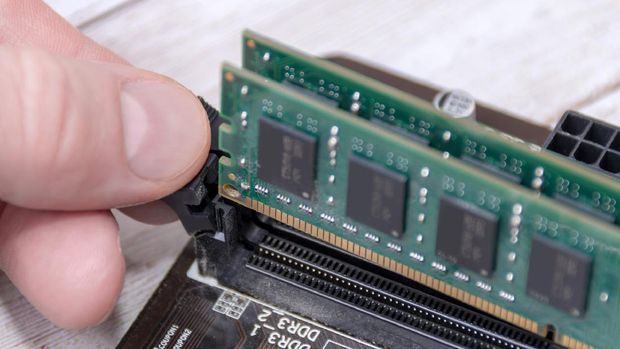 Hand removing DDR RAM - computer memory - part of a desktop computer+ logos and ref numbers removed