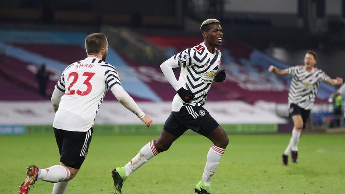 Liga Inggris BURNLEY, ENGLAND - JANUARY 12: Paul Pogba of Manchester United celebrates with Luke Shaw (L) after scoring their teams first goal during the Premier League match between Burnley and Manchester United at Turf Moor on January 12, 2021 in Burnley, England. Sporting stadiums around England remain under strict restrictions due to the Coronavirus Pandemic as Government social distancing laws prohibit fans inside venues resulting in games being played behind closed doors. (Photo by Clive Brunskill/Getty Images)