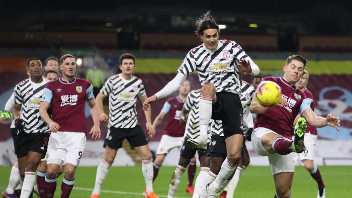 BURNLEY, ENGLAND - JANUARY 12: Edinson Cavani of Manchester United battles for possession with James Tarkowski of Burnley during the Premier League match between Burnley and Manchester United at Turf Moor on January 12, 2021 in Burnley, England. Sporting stadiums around England remain under strict restrictions due to the Coronavirus Pandemic as Government social distancing laws prohibit fans inside venues resulting in games being played behind closed doors. (Photo by Clive Brunskill/Getty Images)