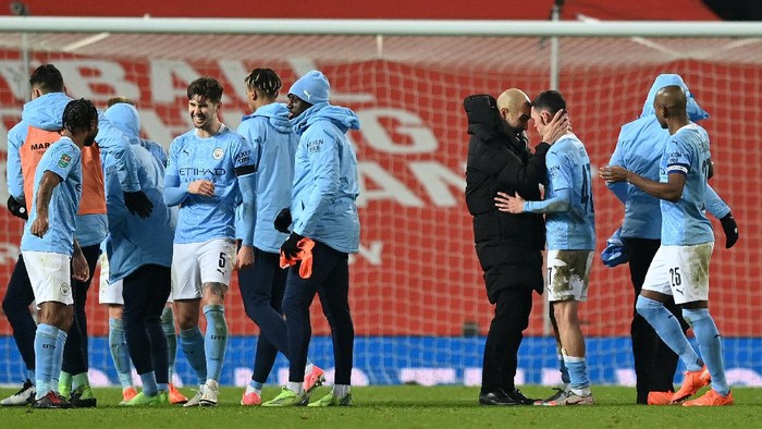 MANCHESTER, ENGLAND - JANUARY 06: Pep Guardiola, Manager of Manchester City celebrates with Phil Foden of Manchester City after the final whistle during the Carabao Cup Semi Final match between Manchester United and Manchester City at Old Trafford on January 06, 2021 in Manchester, England. The match will be played without fans, behind closed doors as a Covid-19 precaution. (Photo by Shaun Botterill/Getty Images)