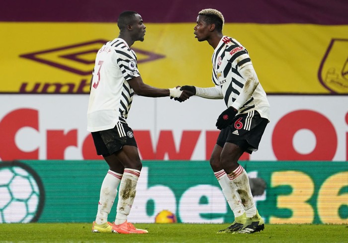 BURNLEY, ENGLAND - JANUARY 12: Paul Pogba of Manchester United celebrates with Eric Bailly after scoring their teams first goal during the Premier League match between Burnley and Manchester United at Turf Moor on January 12, 2021 in Burnley, England. Sporting stadiums around England remain under strict restrictions due to the Coronavirus Pandemic as Government social distancing laws prohibit fans inside venues resulting in games being played behind closed doors. (Photo by Jon Super - Pool/Getty Images)