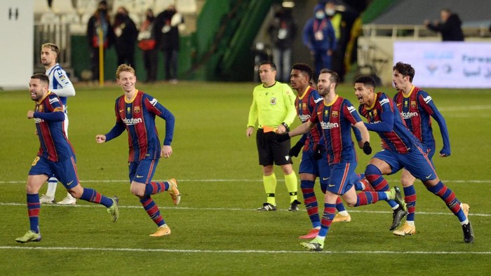 Barcelona players celebrate their victory after the penalty shoot-out in Spanish Super Cup semi final football match between Real Sociedad and FC Barcelona at the Nuevo Arcangel stadium in Cordoba on January 13, 2021. (Photo by CRISTINA QUICLER / AFP)