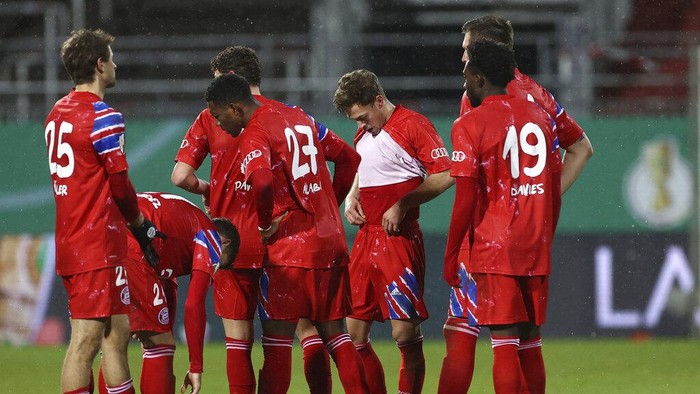 Munichs players stand on the pitch after defeat in the DFB Cup 2nd round match between Holstein Kiel and Bayern Munich at the Holstein Stadium in Kiel, Germany, Wednesday Jan. 13, 2021. (Christian Charisius/dpa via AP)